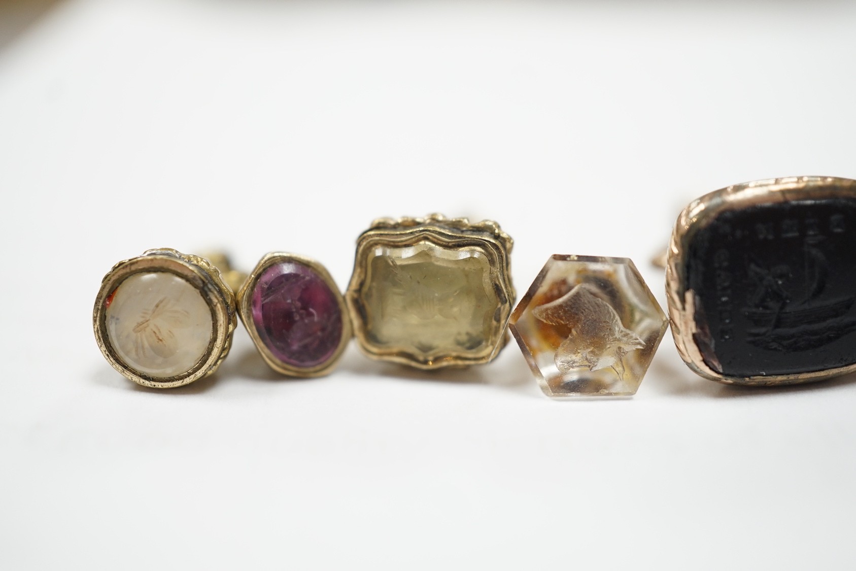 A collection of twelve small 19th century mainly yellow metal fob seals, with assorted matrices including bloodstone, amethyst, citrine and carnelian, largest 22mm.